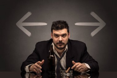 Sarhoş adam oklarla masada oturan