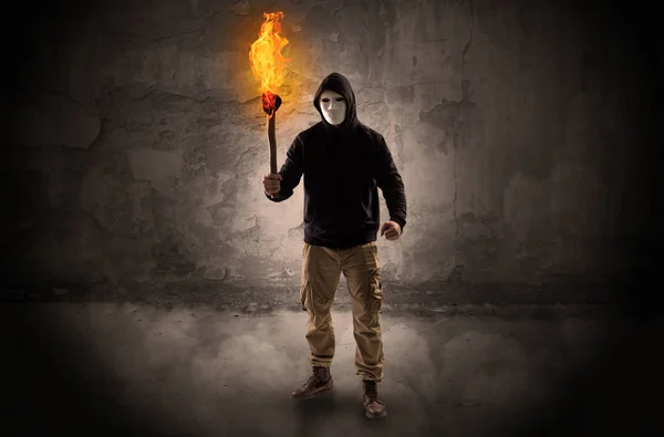 Wayfarer with burning torch in front of crumbly wall concept — Stock Photo, Image