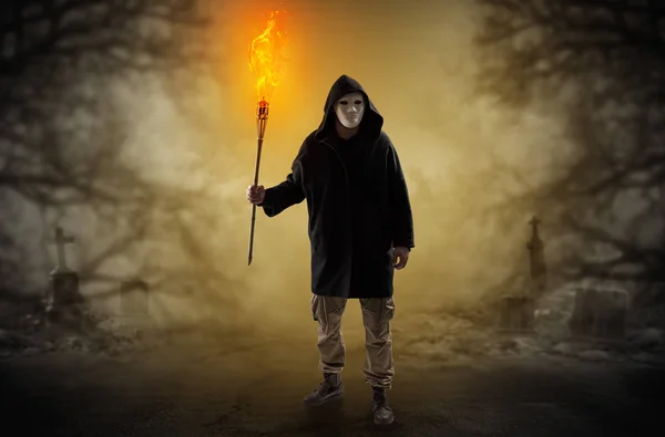 Man coming out from a thicket with burning flambeau — Stock Photo, Image