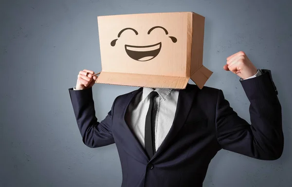 Смешной человек, улыбающийся головой из картонной коробки — стоковое фото