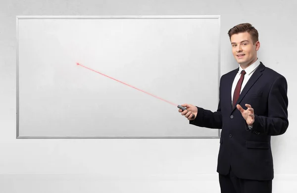 Businessman with laser pointer and copyspace white blackboard — Stock Photo, Image