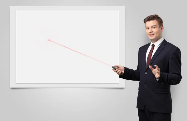 Businessman with laser pointer and copyspace white blackboard — Stock Photo, Image