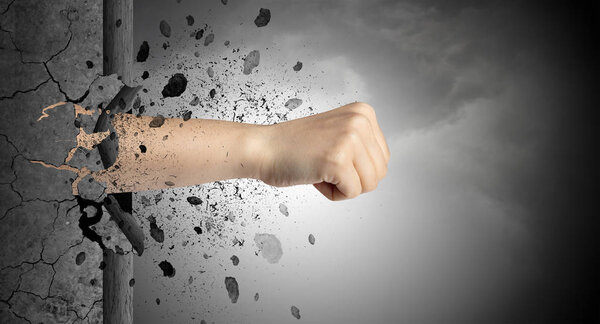 Рука сильно бьет и ломает каменную стену
