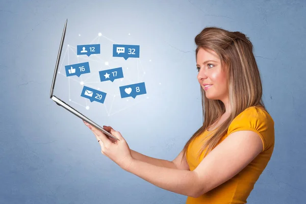 Woma holding laptop with social media notifications — Stock Photo, Image