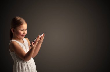 Tablet ile koyu arka plan kullanarak sevimli küçük kız