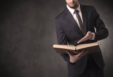 Elinde kitap tutan bir işadamı.