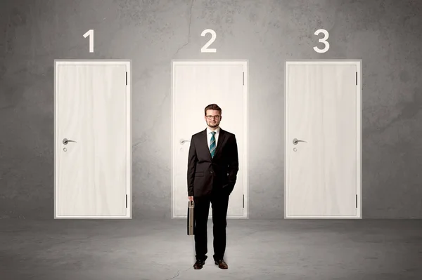 Businessman thinking in front of three doors — Stock Photo, Image