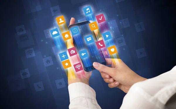 Mão usando smartphone com ícones de aplicativos angulares — Fotografia de Stock