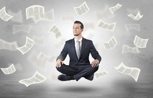 Бизнесмен медитирует с концепцией летающей бумаги — стоковое фото