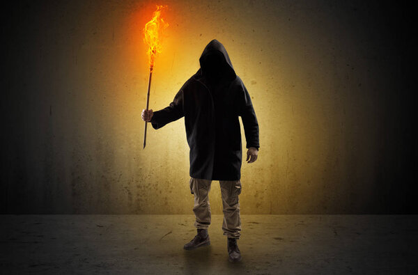 Man walking in an empty space with burning flambeau