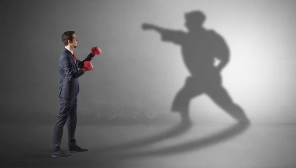 Young businessman fighting with his shadow — Stock Photo, Image