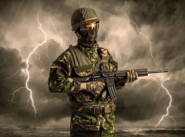 Soldado armado parado en un clima oscuro — Foto de Stock