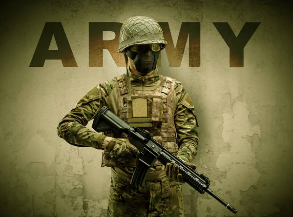 Soldato armato con sfondo muro danneggiato — Foto Stock