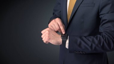 Smartwatch giyen takım elbiseli adam.