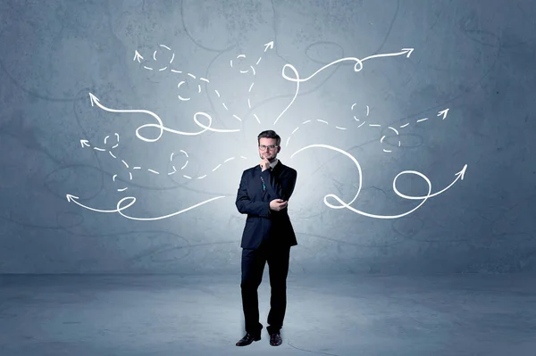 Businessman standing with winding arrows around — Stock Photo, Image