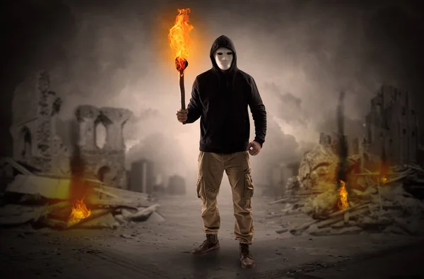 Man coming with burning flambeau at a catastrophe scene concept — Stock Photo, Image