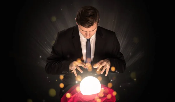 Businessman  sitting with sparkling magic ball