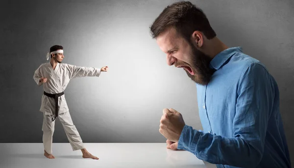 Giant man yelling at a small karate man — Stock Photo, Image