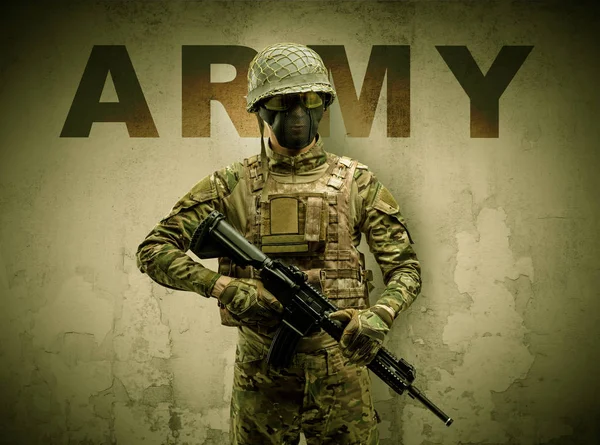 Armed soldier with damaged wall background — Stock Photo, Image