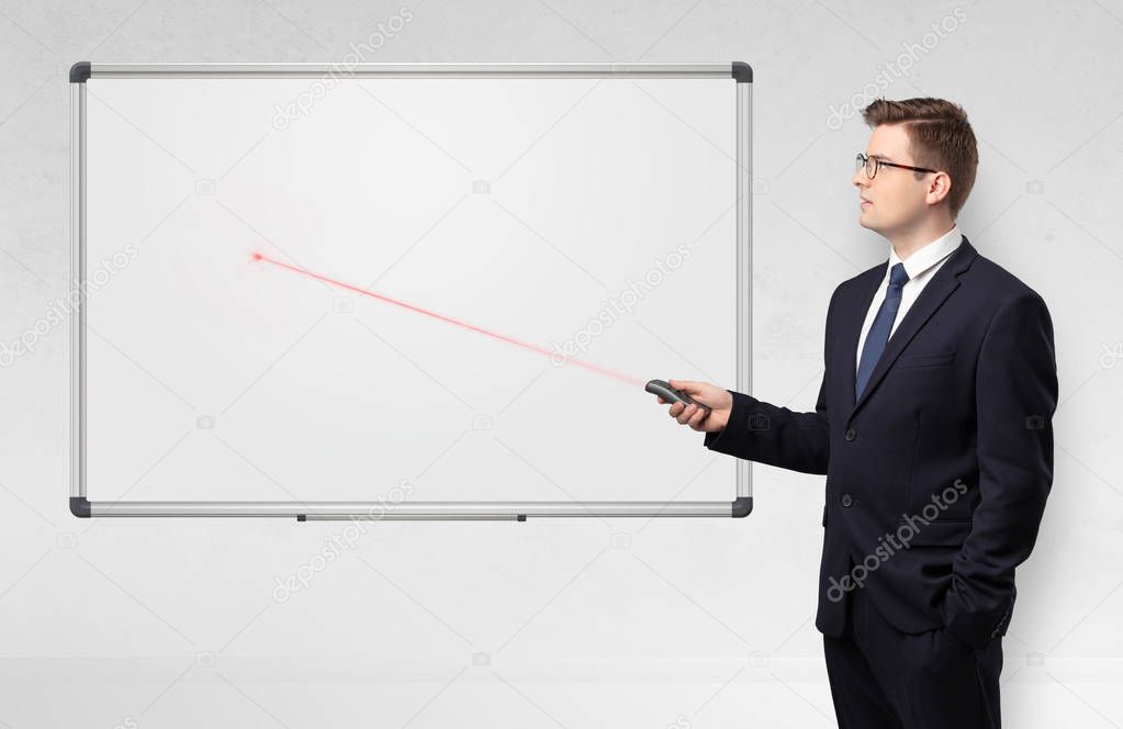 Businessman with laser pointer and copyspace white blackboard