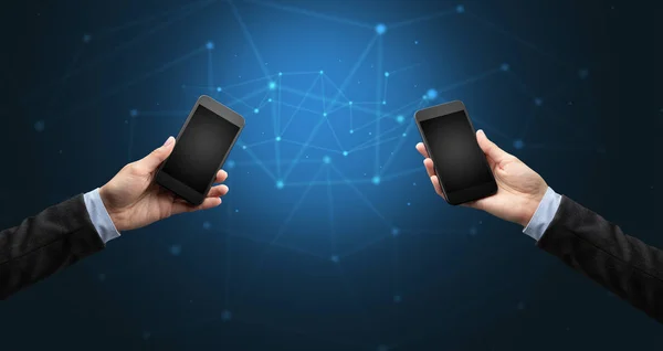 Close up of two hands holding smartphones — Stock Photo, Image