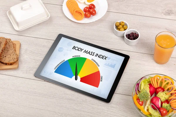 Healthy food with tablet on a wooden background