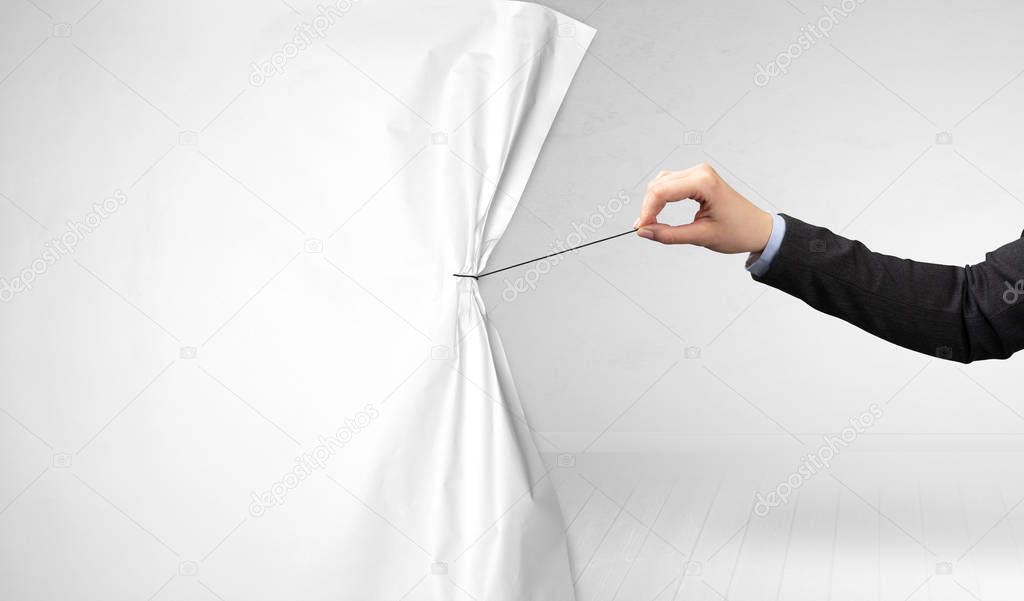 hand pulling white paper curtain