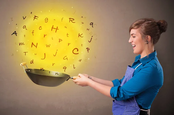 Person cooking letters in wok — Stock Photo, Image