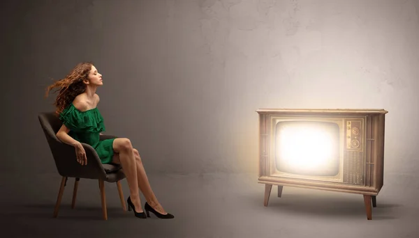 Young lady watching to a vintage television — Stock Photo, Image