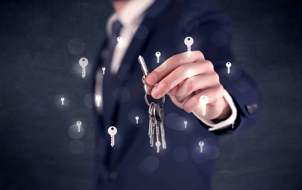 Geschäftsmann hält Schlüssel mit Schlüssel herum — Stockfoto