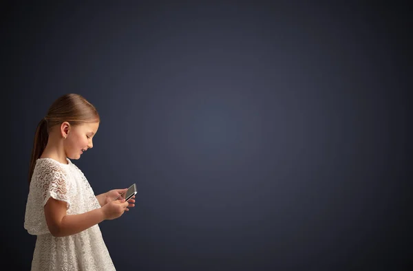Cute little girl using tablet with dark background Royalty Free Stock Photos
