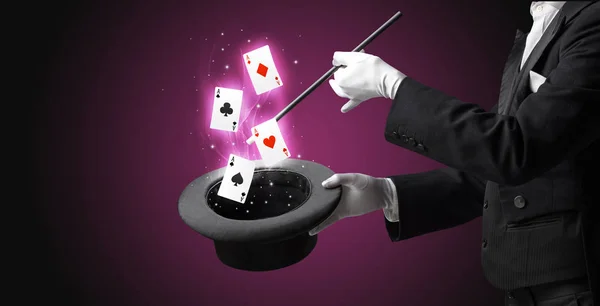 Magician making trick with wand and playing cards — Stock Photo, Image
