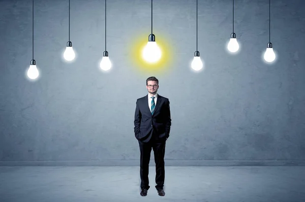 Businessman standing uninspired with bulbs above — Stock Photo, Image