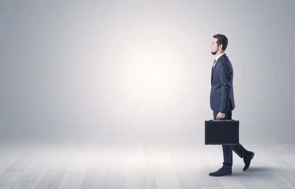 Empresario caminando frente a una pared vacía — Foto de Stock