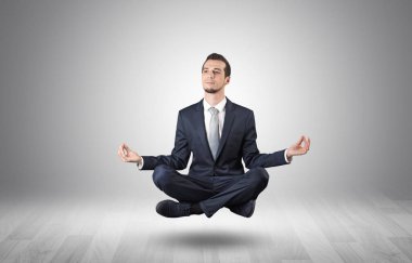 Businessman meditates in an empty space concept clipart