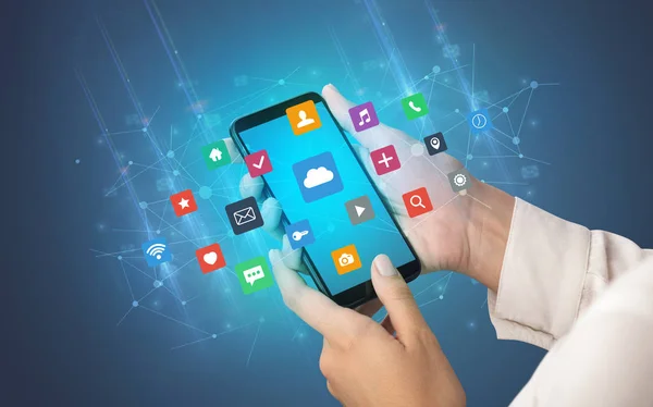 Main utilisant un smartphone avec des icônes d'application — Photo