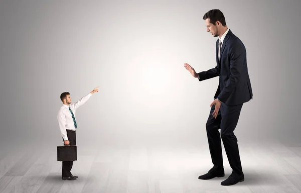 Pequeno empresário apontando para um empresário gigante — Fotografia de Stock