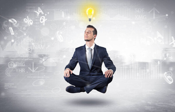 Businessman meditates with enlightenment concept