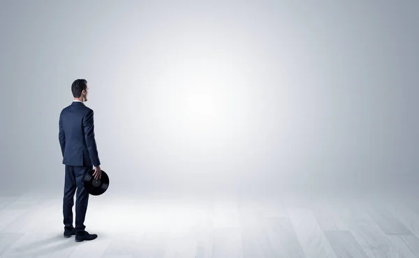 Mann mit Gegenstand in der Hand in einem leeren Raum — Stockfoto