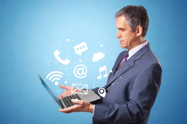 Man holding laptop with online symbols — Stock Photo, Image
