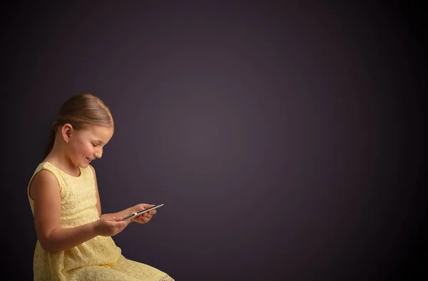 어두운 배경으로 태블릿을 사용 하 여 귀여운 소녀 — 스톡 사진
