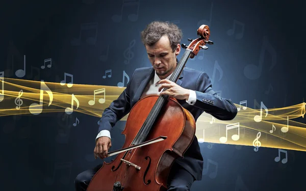 Músico tocando el violonchelo con notas alrededor —  Fotos de Stock