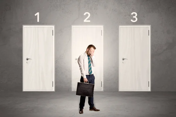 Businessman thinking in front of three doors — Stock Photo, Image