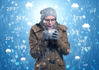 Genç adam hava durumu ve tahmin konsepti ile sıcak giysiler içinde dondurma