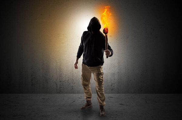 Man walking in an empty space with burning flambeau