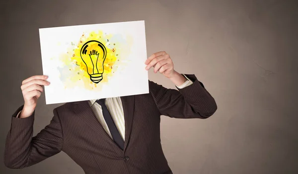 Person som innehar ett papper med färgglada glödlampa koncept — Stockfoto
