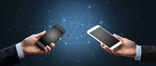Primer plano de dos manos sosteniendo teléfonos inteligentes —  Fotos de Stock