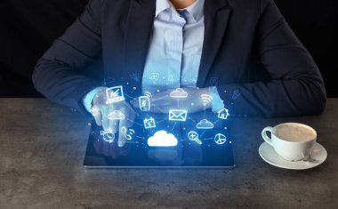 Yukarıdaki uygulama simgeleriyle tablet üzerinde çalışan iş kadın