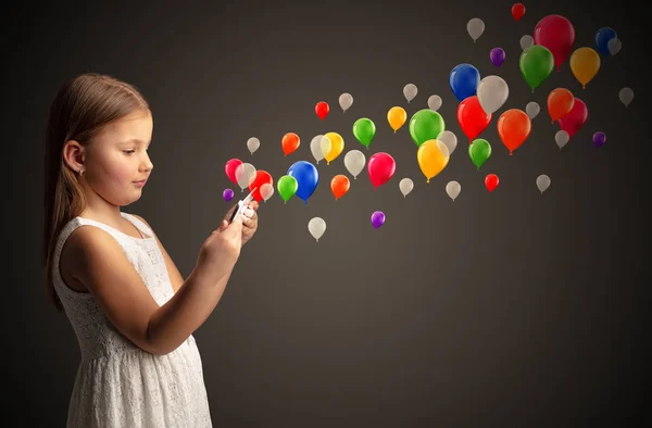 Flicka innehav tablett med färgglada ballonger runt — Stockfoto