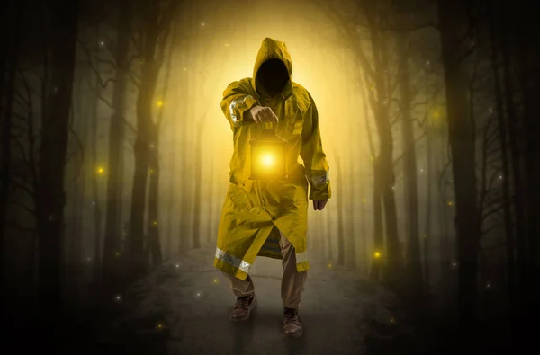 Mysterious man coming from a path in the forest with glowing lantern concept — Stock Photo, Image